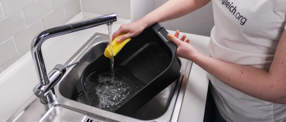 Bräter im Test: Reinigung in der Spüle unter fließendem Wasser und mit einem Schwamm