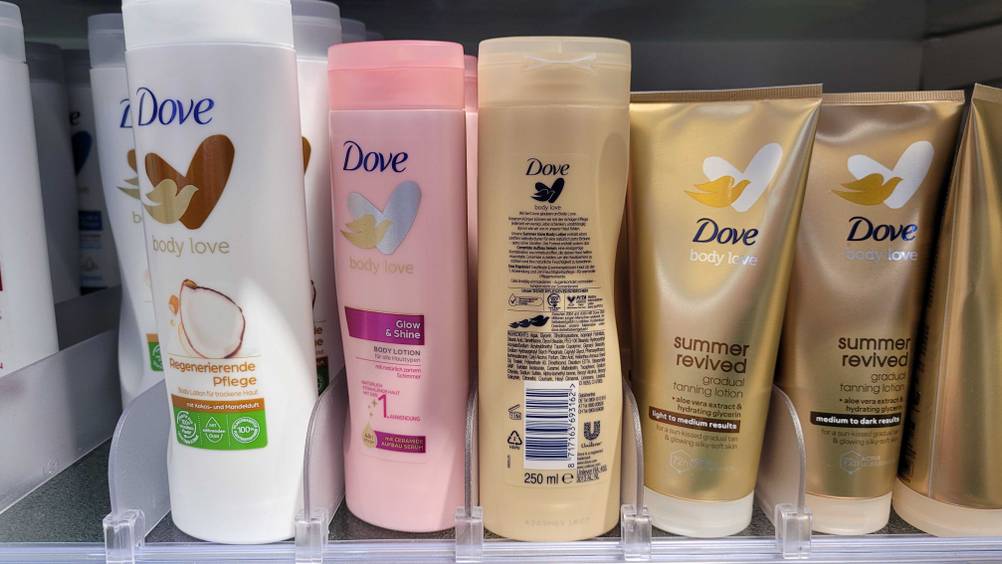 Bräunende Bodylotion getestet: Eine Flasche mit der Rückseite nach vorne in einem Verkaufsregal neben anderen Produkten.
