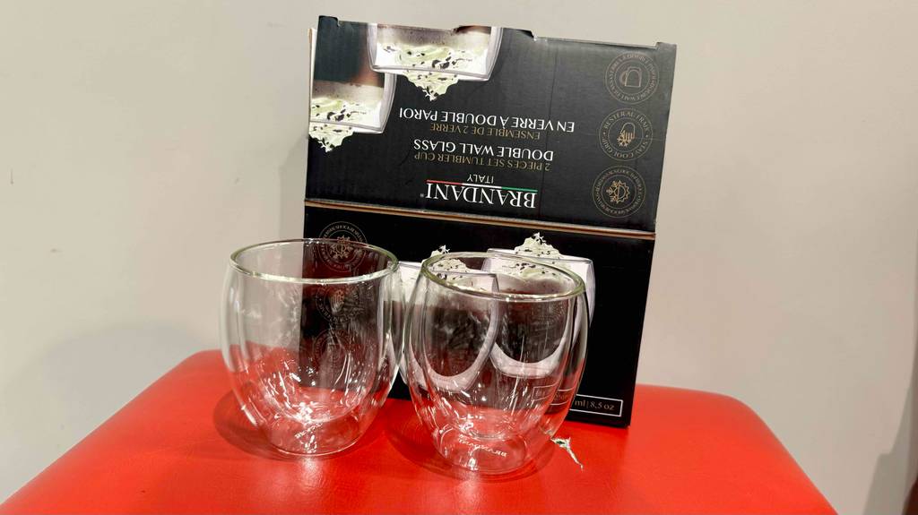 Zwei doppelwandige Gläser im Test stehen vor einem schwarzen Verpackungskarton.