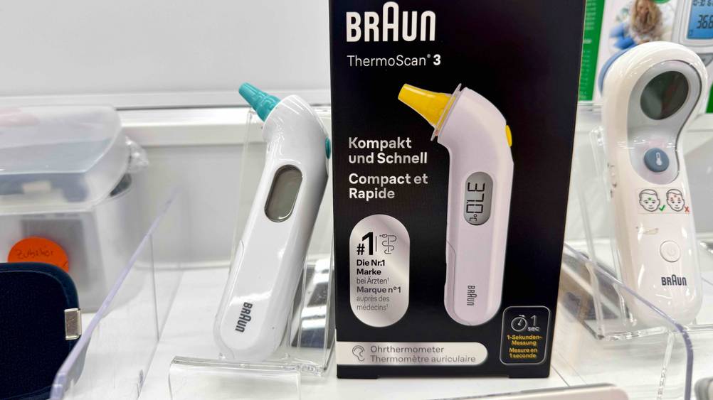 Neben der Originalverpackung befindet sich das Braun-Fieberthermometer im Test in einem transparenten Ständer.