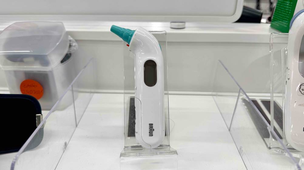 Auf einem Verkaufsregal befindet sich das getestete Braun-Fieberthermometer in eine Ständer.