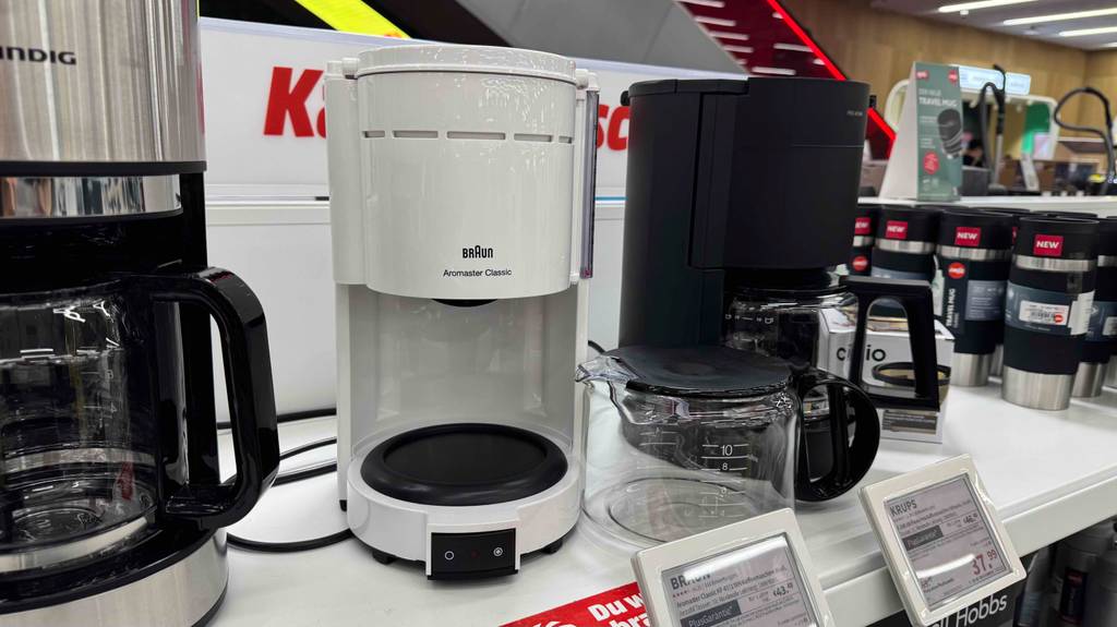 Kaffeemaschine in weiß im Test: Die Glaskanne steht neben der Maschine.