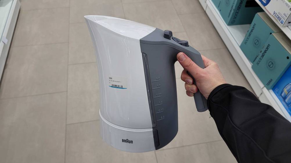 Eine Hand hält den Braun-Wasserkocher im Test hoch.