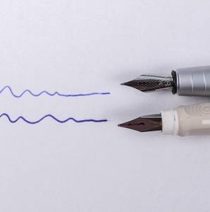 Rechts sind die Federn zweier Füller zu sehen, links die Linien, die damit gezogen wurden.