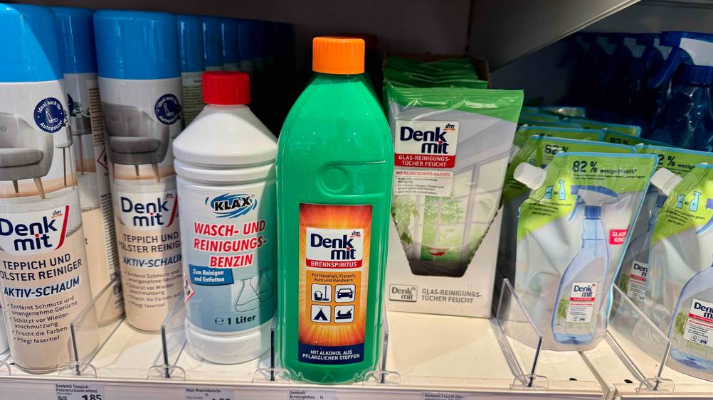 Mehrerer Flaschen des getesteten Brennspiritus stehen neben anderen Produkten in einem Verkaufsregal.