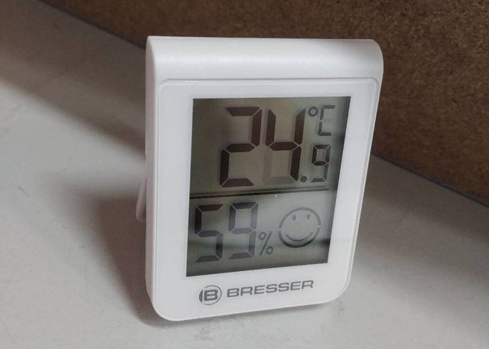 Weißes, getestetes Thermometer von Bresser befindet sich vor dunklem Hintergrund.
