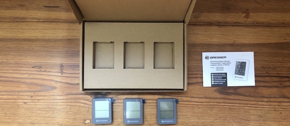 Lieferumfang mehrerer digitaler Bresser-Thermometer mit Verpackung und Anleitung auf Holzoberfläche.