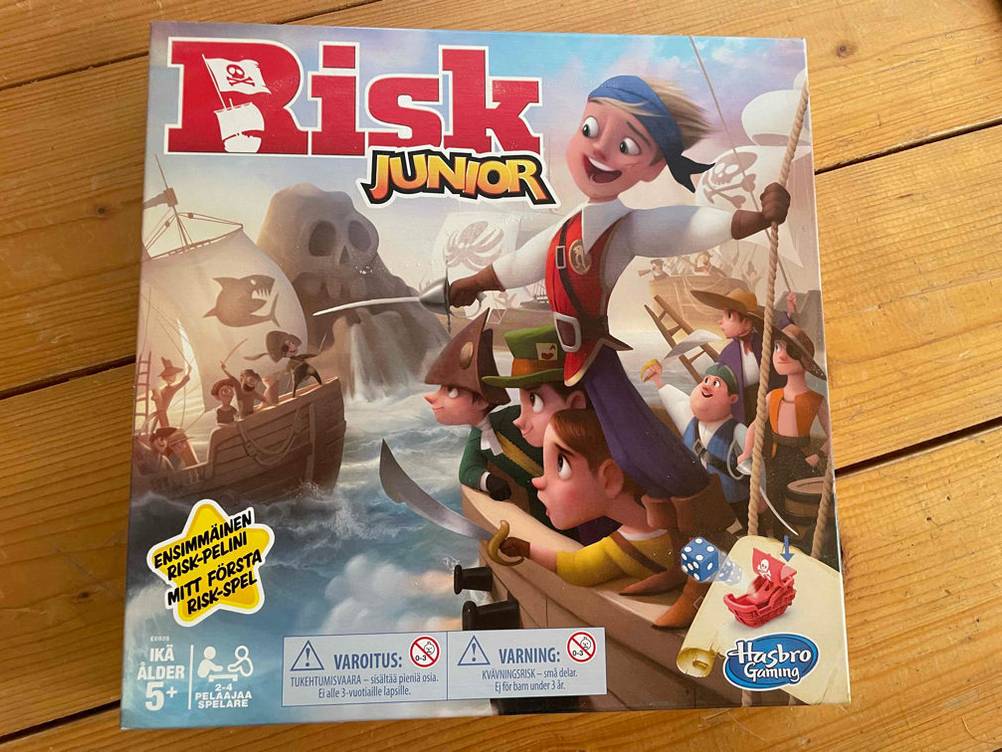 Brettspiele getestet: Eine Packung Risk Junior auf einer Holzfläche.