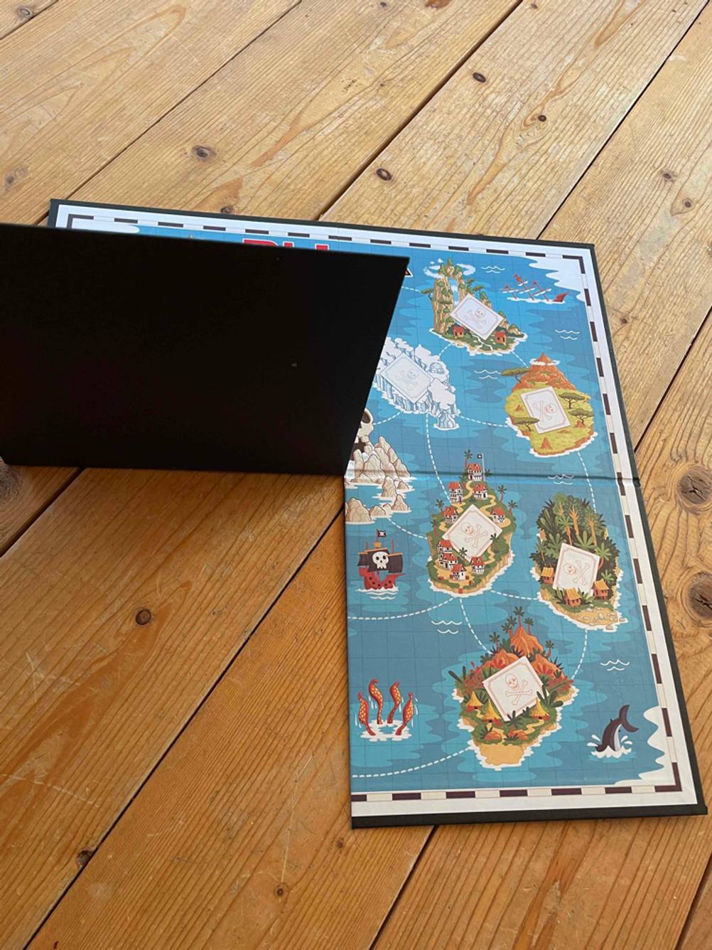 Brettspiele getestet: Ein Spielbrett wird auf einer Seite angehoben.
