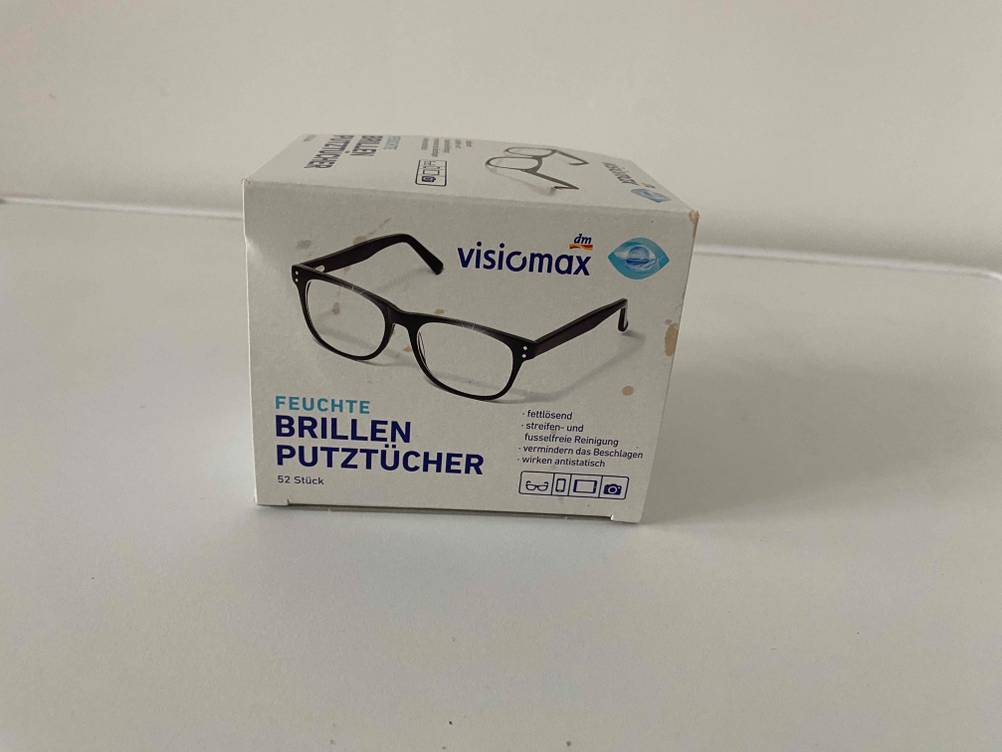 Auf einer hellen Fläche steht eine Packung Brillenputztücher im Test.