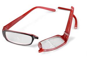 Test der Brillenversicherungen: Eine zerbrochene rote Brille liegt auf einem weißen Untergrund.