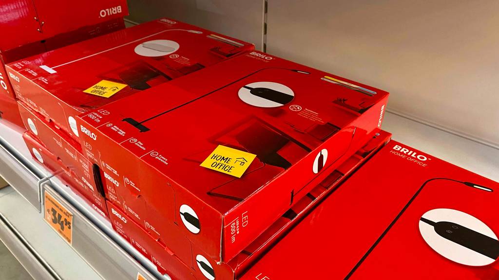 Stehlampe für das Büro im Test: mehrere Originalverpackungen liegen gestapelt auf- und nebeneinander in einem Regal.