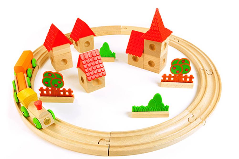 Brio-Eisenbahn im Test: Eine Zum Kreis gelegte Schienenstrecke mit manuellem Zug und Häusern.