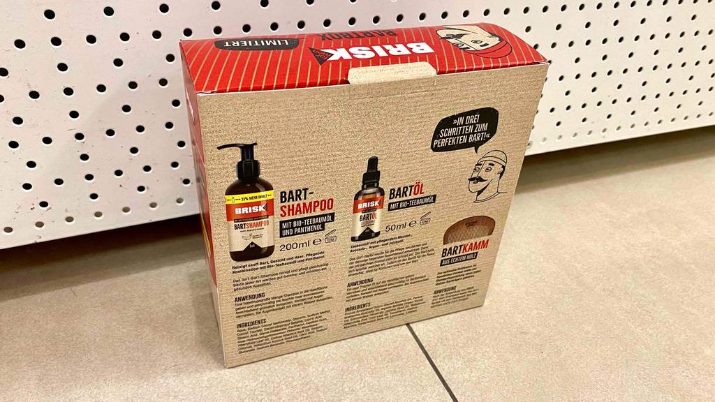 Bartpflege-Set-Test: Brisk Bartbox Verpackung steht mit der Rückseite inklusive Produktbeschreibung im Fokus vor beigefarbiger Fläche.