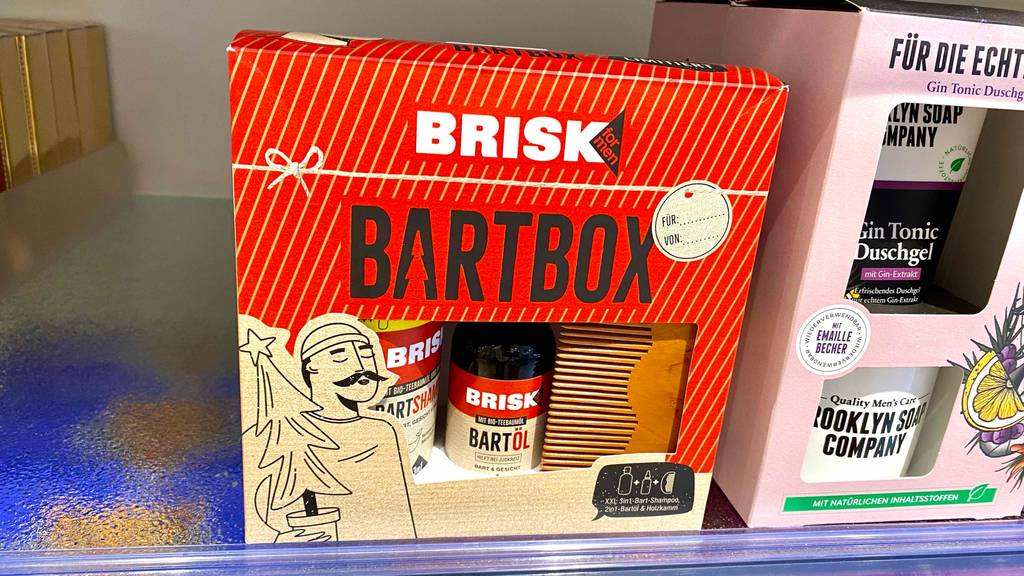 Bartpflege-Set-Test: Brisk Bartbox im beige-roten Design steht auf einem Verkaufsregal neben Gin Tonic Duschgel.