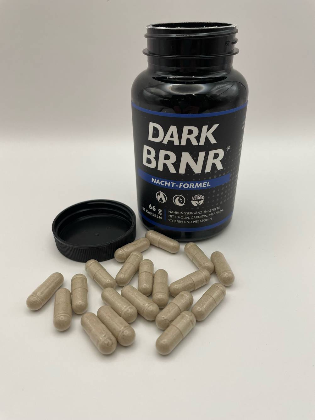 Fatburner im Test: Vor einer geöffneten Dose liegen mehrere Kapseln.