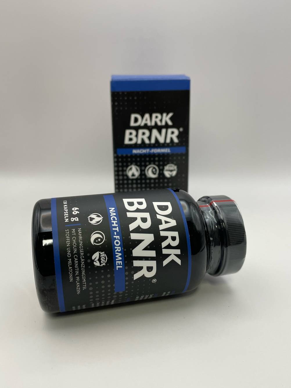 Ein Glas Fatburner liegt zum testen quer vor dem Originalkarton.