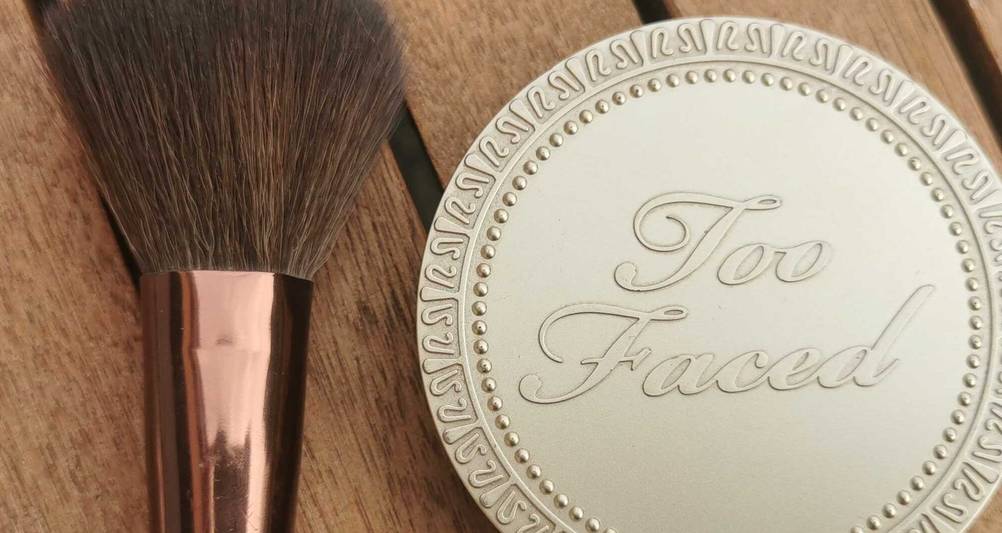 Der getestete Bronzer in Nahaufnahme neben einem Pinsel.