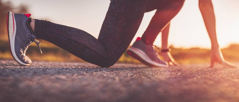 Brooks-Laufschuhe-Damen-Test: Eine Frau mit Laufschuhen in Startposition. 