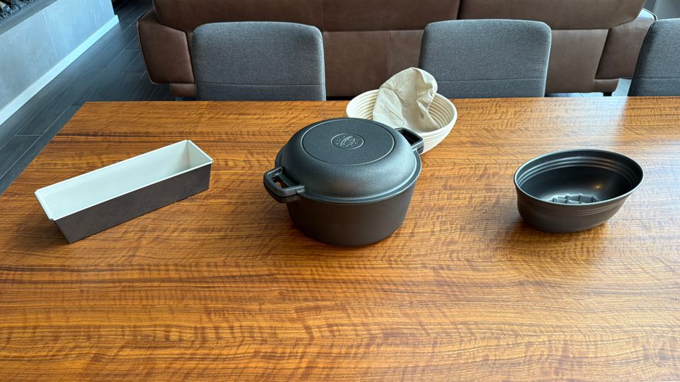 Drei Brotbackformen stehen nebeneinander auf einem Holztisch