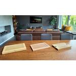 Drei Brotschneidebretter liegen nebeneinander auf einem Holztisch