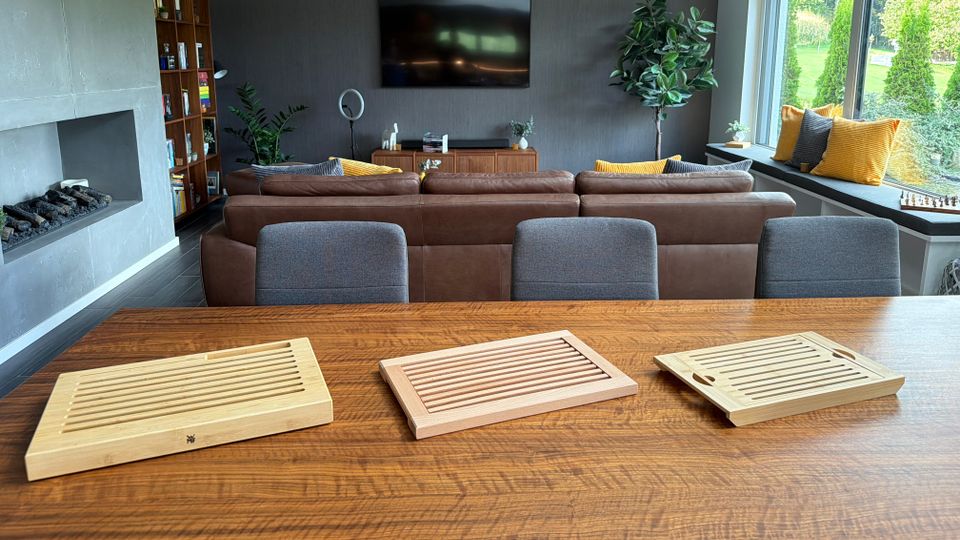 Drei Brotschneidebretter liegen nebeneinander auf einem Holztisch