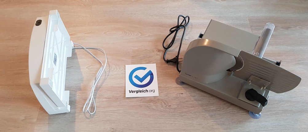 weiße, klappbare Maschine und graue, nicht klappbare Maschine auf einem Holzboden