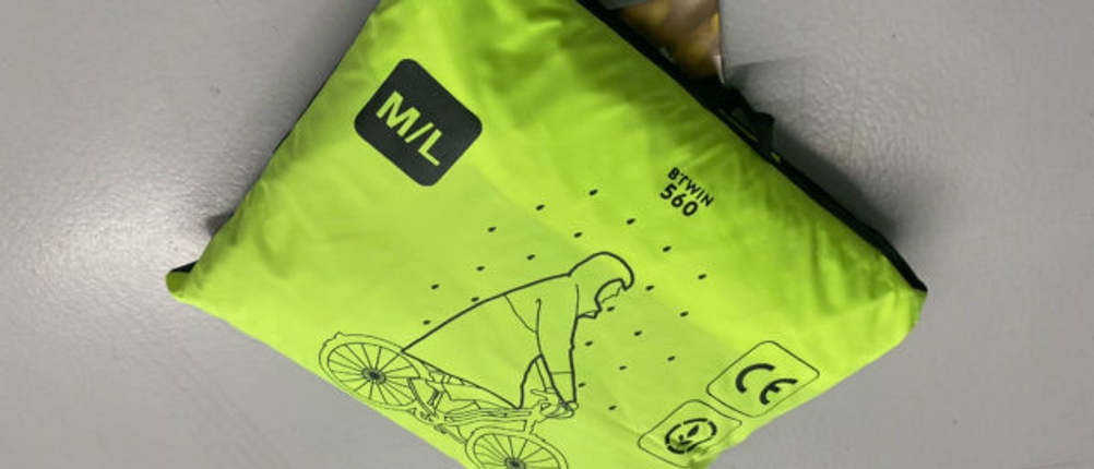 Regenponcho-Test: Verpackter, giftgrüner btwin-Regenponcho 