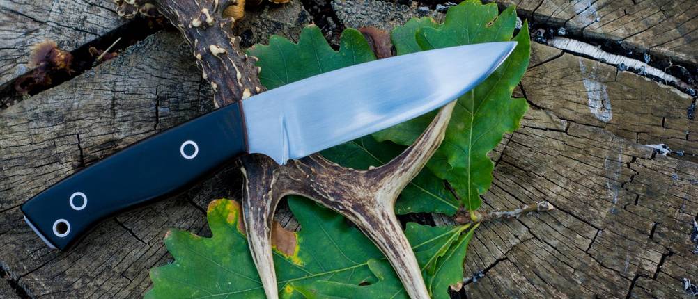 Buck-Messer im Test: Jagdmesser auf einem Baumstumpf und einem Geweih