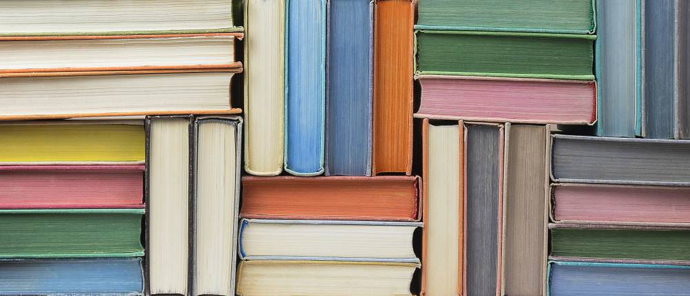 Bücher-Verkaufen-Test: Viele bunte alte Bücher übereinander gestapelt.