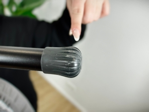 Nahaufnahme der Anti-Rutsch-Kappen des Brabantia-345647J-Bügelbretts. Eine Person zeigt mit dem Finger darauf.