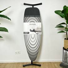 Das Brabantia 345647J Bügelbrett steht aufrecht mit sichtbarer Verpackung. Die Vorderseite zeigt das Produktbild und Funktionen.