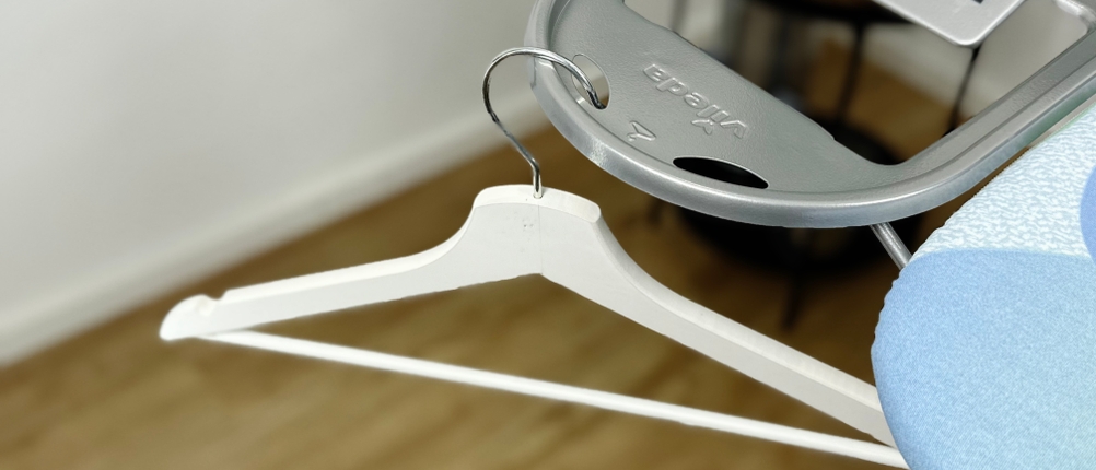 Die hitzebeständige Ablage des Vileda-161484-Bügelbretts mit einer Metallhalterung für das Bügeleisen. Ein weißer Kleiderbügel hängt an einem integrierten Haken.