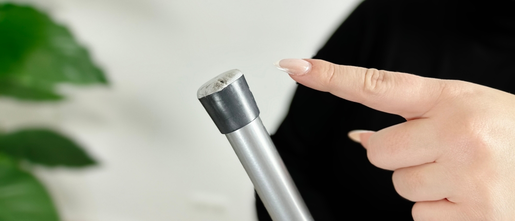 Eine Hand zeigt auf die Anti-Rutsch-Kappe des Vileda-161484-Bügelbretts. 