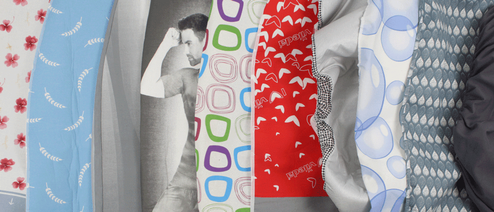 verschiedene Bügelbrettbezüge nebeneinander, dazwischen ein Mann, der den Bizeps spielen lässt