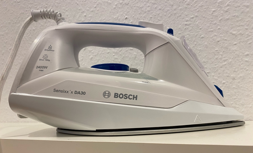 Bügeleisen getestet: Ein Gerät von der Seite mit Logo auf einer hellen Fläche.