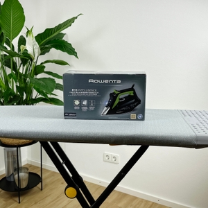 Die Vorderseite der Verpackung des Rowenta DW6330D1 Eco Intelligence Dampfbügeleisens steht auf einem grauen Bügelbrett. Das Bügeleisen ist als Produktabbildung zu sehen, ergänzt durch grüne Symbole für Eco-Modus und Dampffunktionen.
