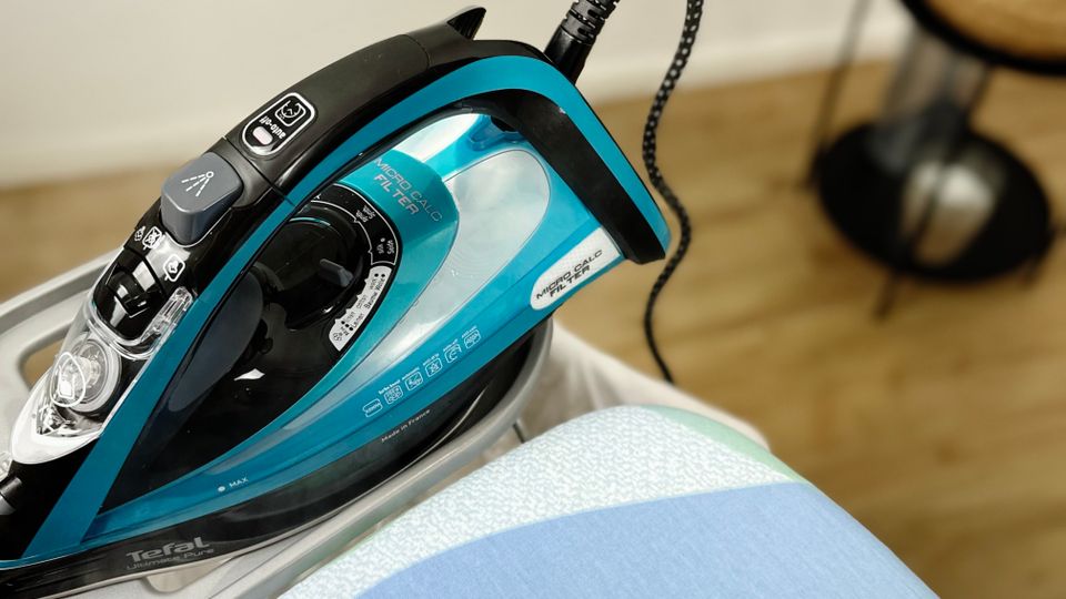Die Bedienelemente des Tefal FV9844 Dampfbügeleisens sind in Nahaufnahme zu sehen. Der Sprühknopf, der Dampfregler und der Temperaturdrehknopf befinden sich im oberen Bereich des Geräts.