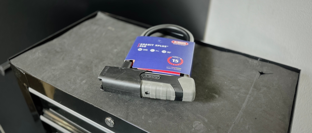 Das Bügelschloss von Abus liegt eingepackt auf einem Rollwagen.