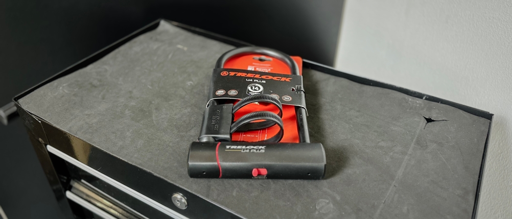 Das Bügelschloss von Trelock liegt eingepackt auf einem Rollwagen.