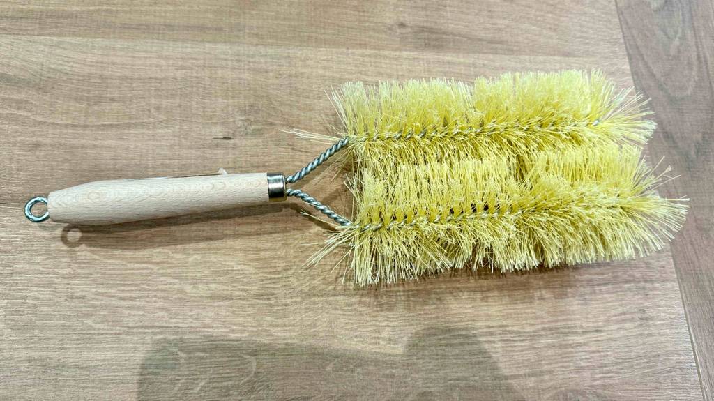 Nahansicht einer Heizkörperbürste, die zum testen auf einer Holzfläche liegt.