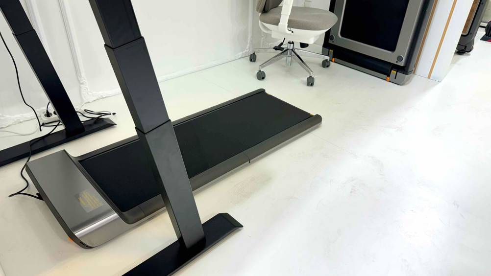 Ein getestetes Büro-Laufband von schräg vorne auf einem hellen Boden, im Hintergrund ein Bürostuhl.