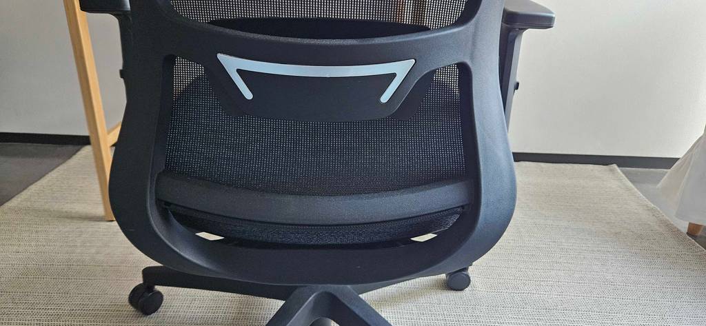Getesteter Bürostuhl auf Rollen steht auf einem hellen Teppich.