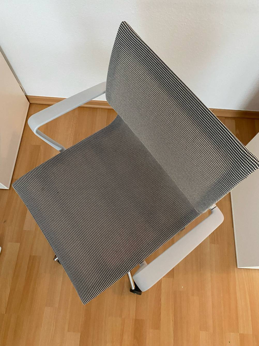 Getestet: Ein Bürostuhl von oben betrachtet auf einem Holzboden.