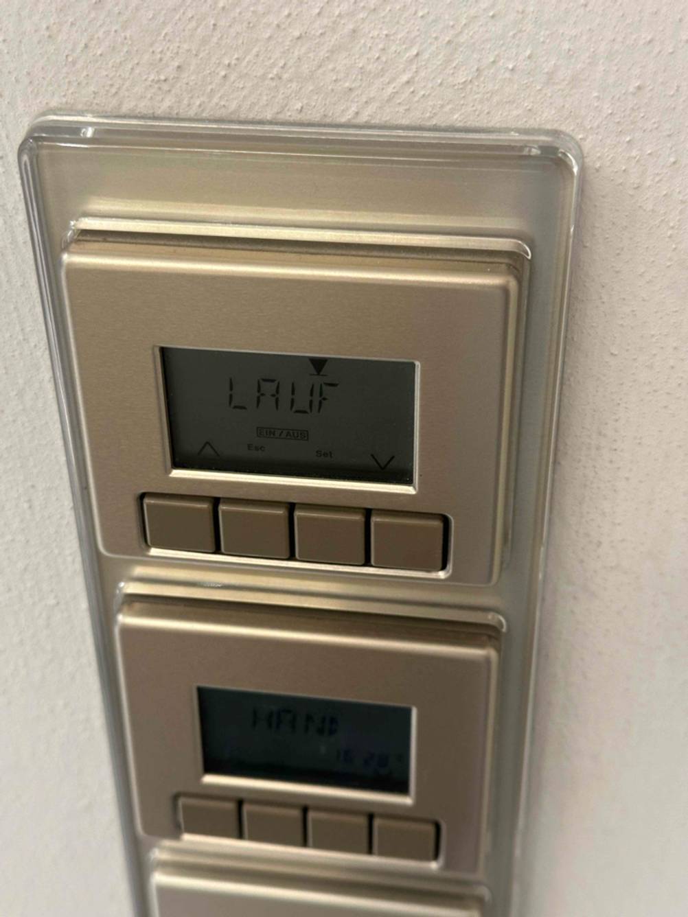 Eine Rollladen-Zeitschaltuhr im Test steht in der LCD-Anzeige auf Lauf.