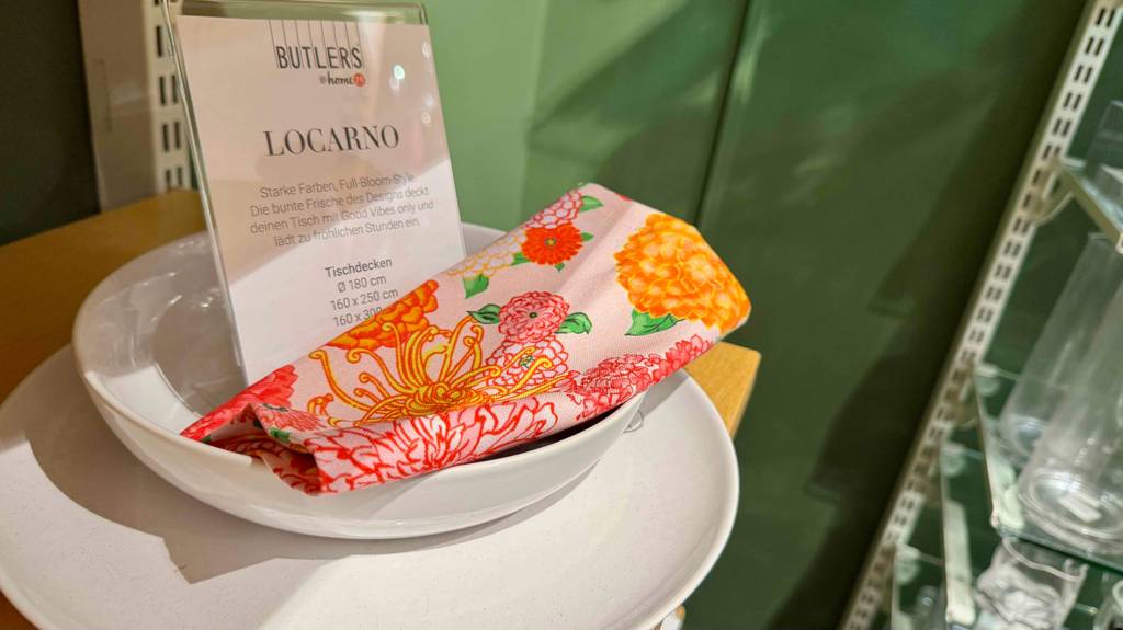 Auf einem weißen Service liegt eine bunte, mit Blumenmuster bedruckte Stoffserviette im Test.