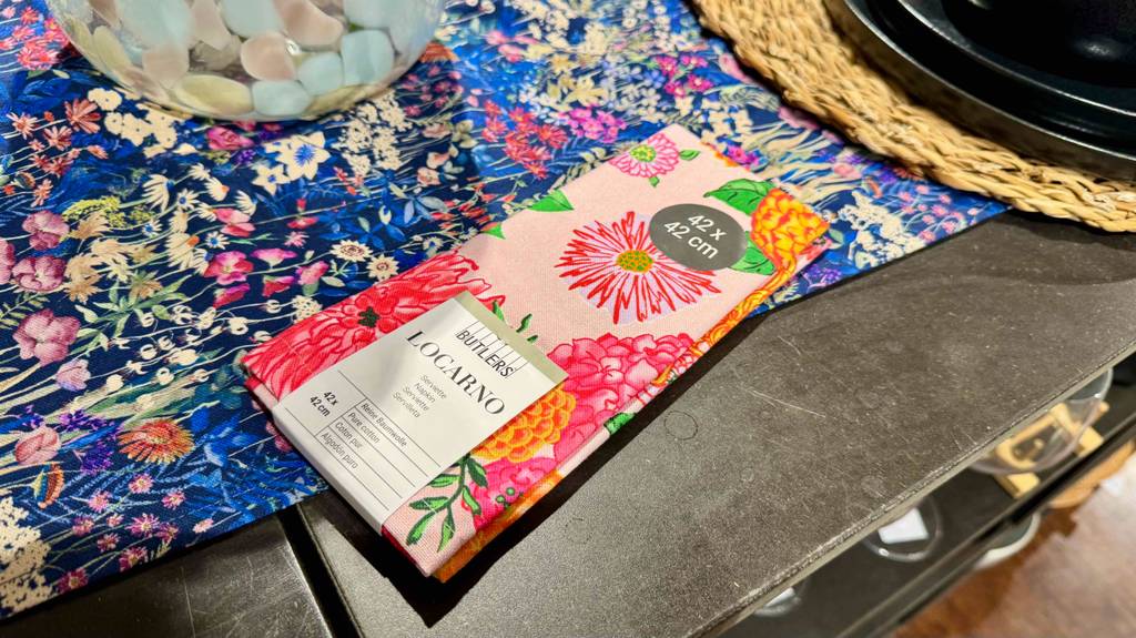 Stoffservietten-Test: Die bunte, 42 x42 cm große Serviette mit Blumenmuster liegt gefaltet auf einer buntem Tischdecke.