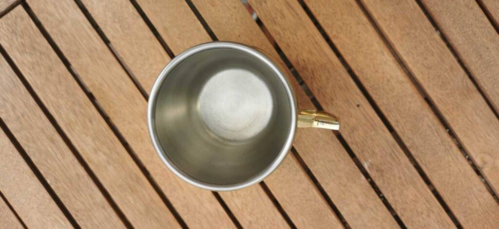 Blick von oben auf einen getesteten Moscow Mule Becher, der auf einer Holzoberfläche steht.