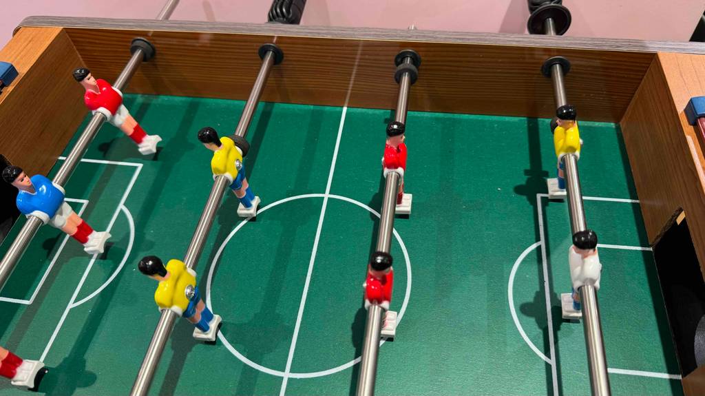 Im Test: Ein Kinder-Tischkicker, dessen grünes Spielfeld im Fokus liegt.