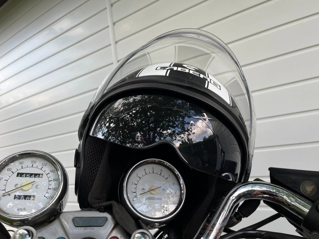 Ein Jethelm Retro sitzt getestet auf dem Umdrehungsmesser eines Motorrads.